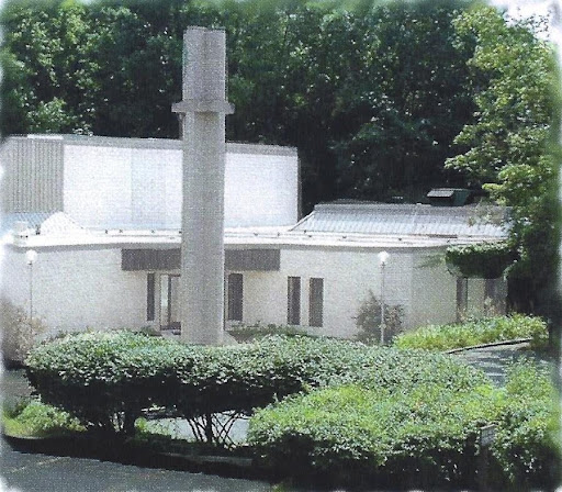 University Reformed Church’s building on Hagadorn Road, with its concrete spire among the trees.
